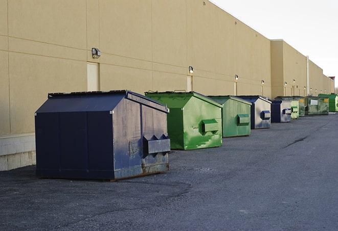 a row of yellow and blue dumpsters at a construction site in Atlanta IN